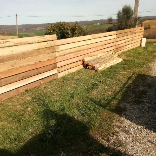 Clôture bois rustique par sola près d’un chemin de gravier, paysage champêtre ensoleillé à limoux